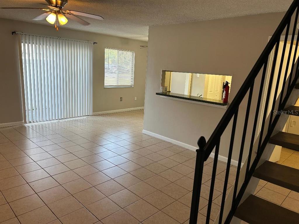 5582 Green Shadows Place, Unit 202 Orlando, FL 32811 - Photo 5 of 19 a view of an empty room with wooden floor and windows