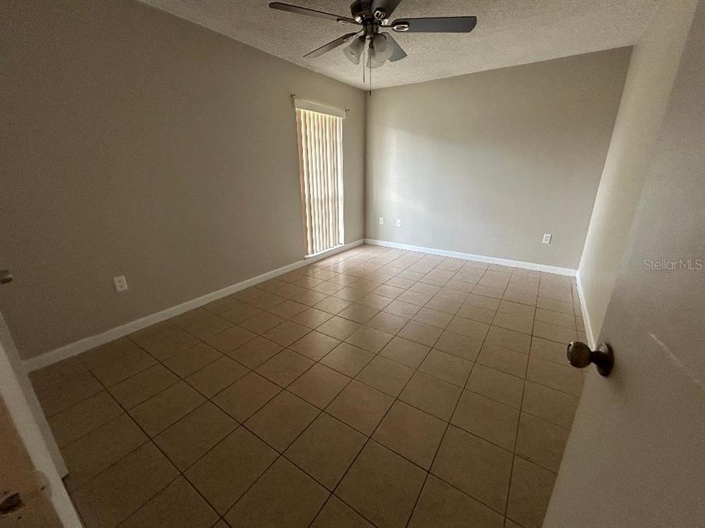 5582 Green Shadows Place, Unit 202 Orlando, FL 32811 - Photo 9 of 19 a view of an empty room and a window