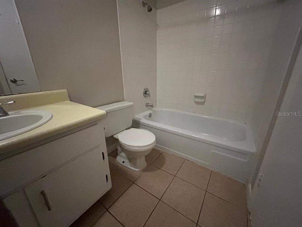 5582 Green Shadows Place, Unit 202 Orlando, FL 32811 - Photo 10 of 19 a bathroom with a sink a toilet and bathtub