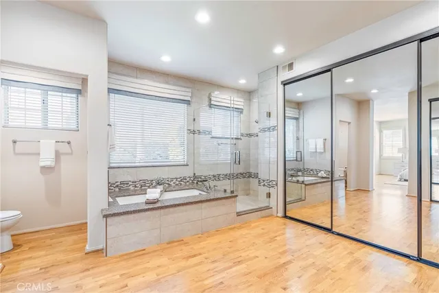 a spacious bathroom with a granite countertop sink a mirror and a shower