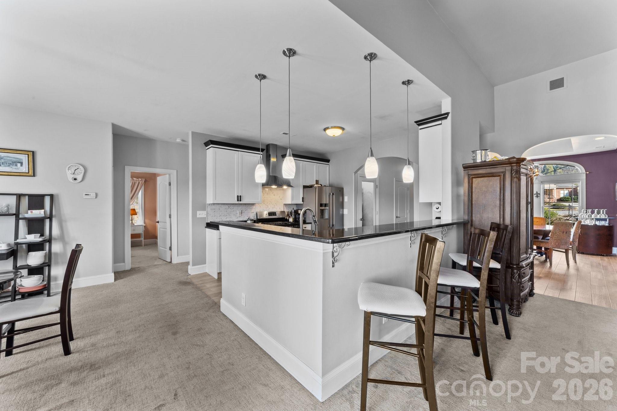 543 Muirfield Way Salisbury, NC 28144 - Photo 12 of 42 a kitchen with stainless steel appliances kitchen island granite countertop a table chairs and a refrigerator