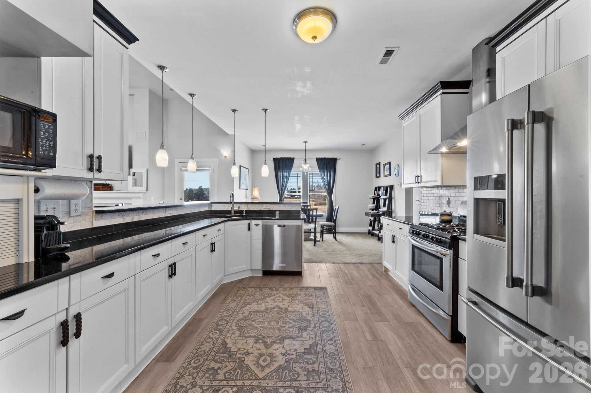 543 Muirfield Way Salisbury, NC 28144 - Photo 15 of 42 a large kitchen with stainless steel appliances lots of counter space and wooden floor