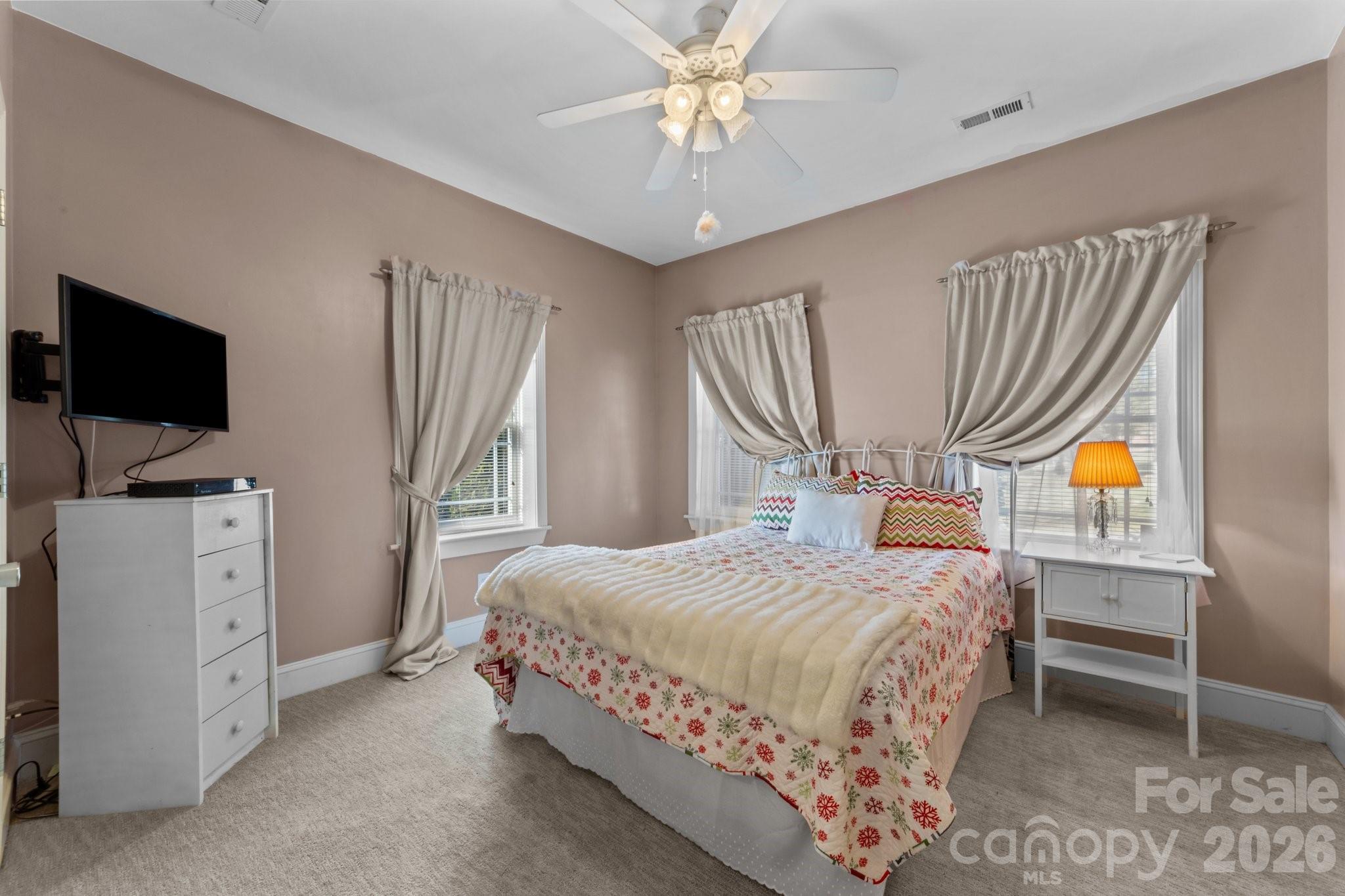 543 Muirfield Way Salisbury, NC 28144 - Photo 22 of 42 a bedroom with a bed and a flat tv screen on dresser