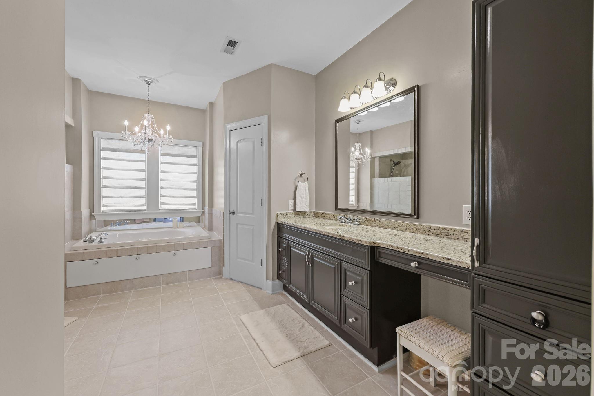 543 Muirfield Way Salisbury, NC 28144 - Photo 26 of 42 a bathroom with a granite countertop sink a toilet a mirror and a bathtub