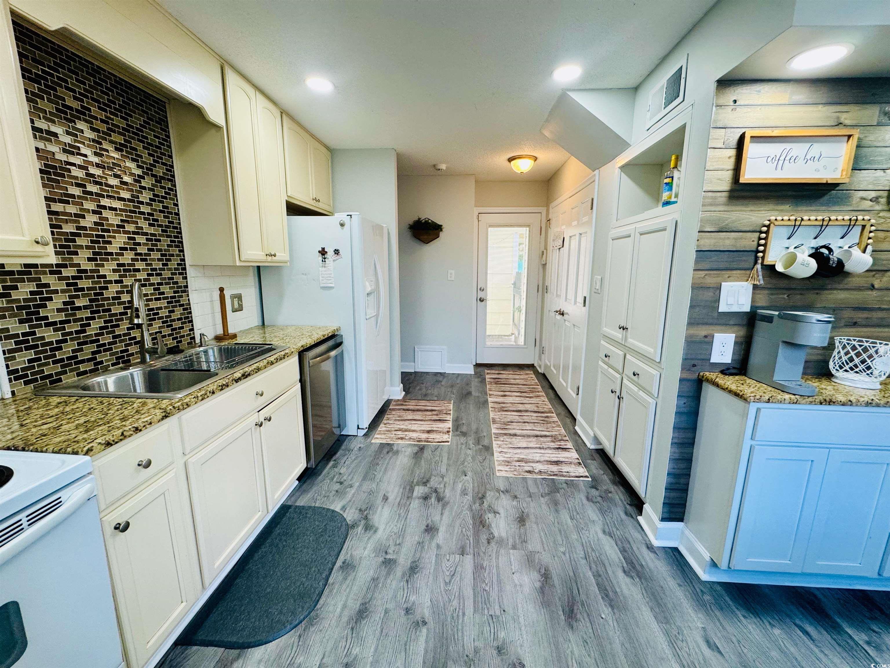 1960 Lake View Circle Surfside Beach, SC 29575 - Photo 15 of 40 Kitchen featuring dark wood-style flooring, decorative backsplash, dishwasher, light stone countertops, and recessed lighting