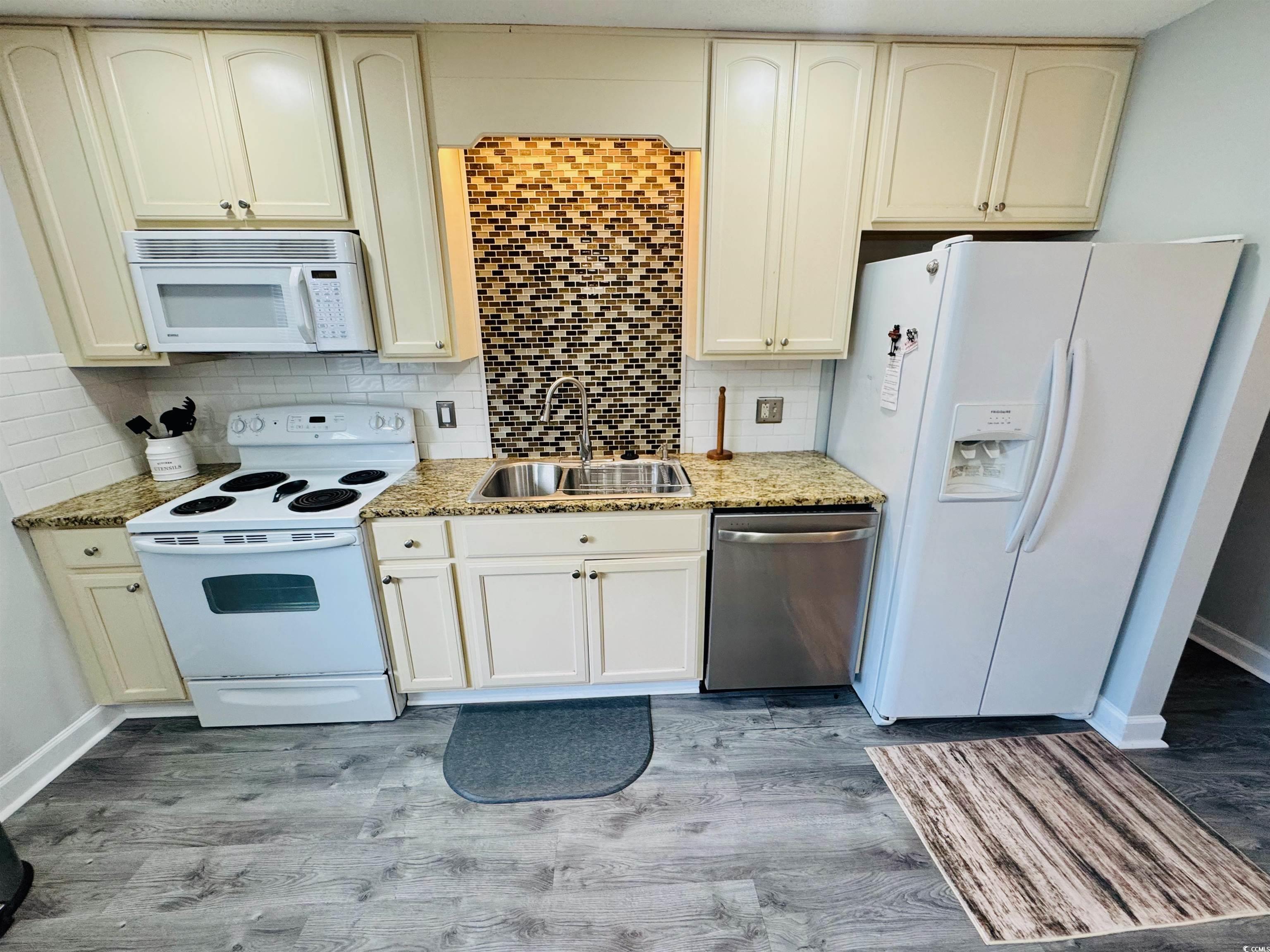 1960 Lake View Circle Surfside Beach, SC 29575 - Photo 16 of 40 Kitchen featuring white appliances, cream cabinetry, tasteful backsplash, and light stone countertops