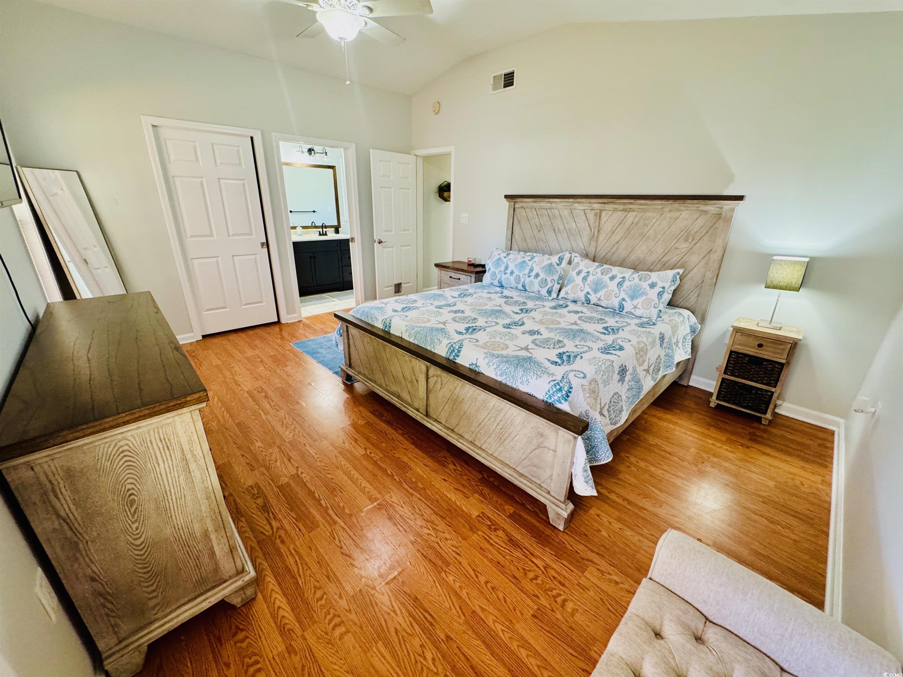 1960 Lake View Circle Surfside Beach, SC 29575 - Photo 21 of 40 Bedroom featuring ensuite bathroom, light wood-type flooring, vaulted ceiling, and ceiling fan