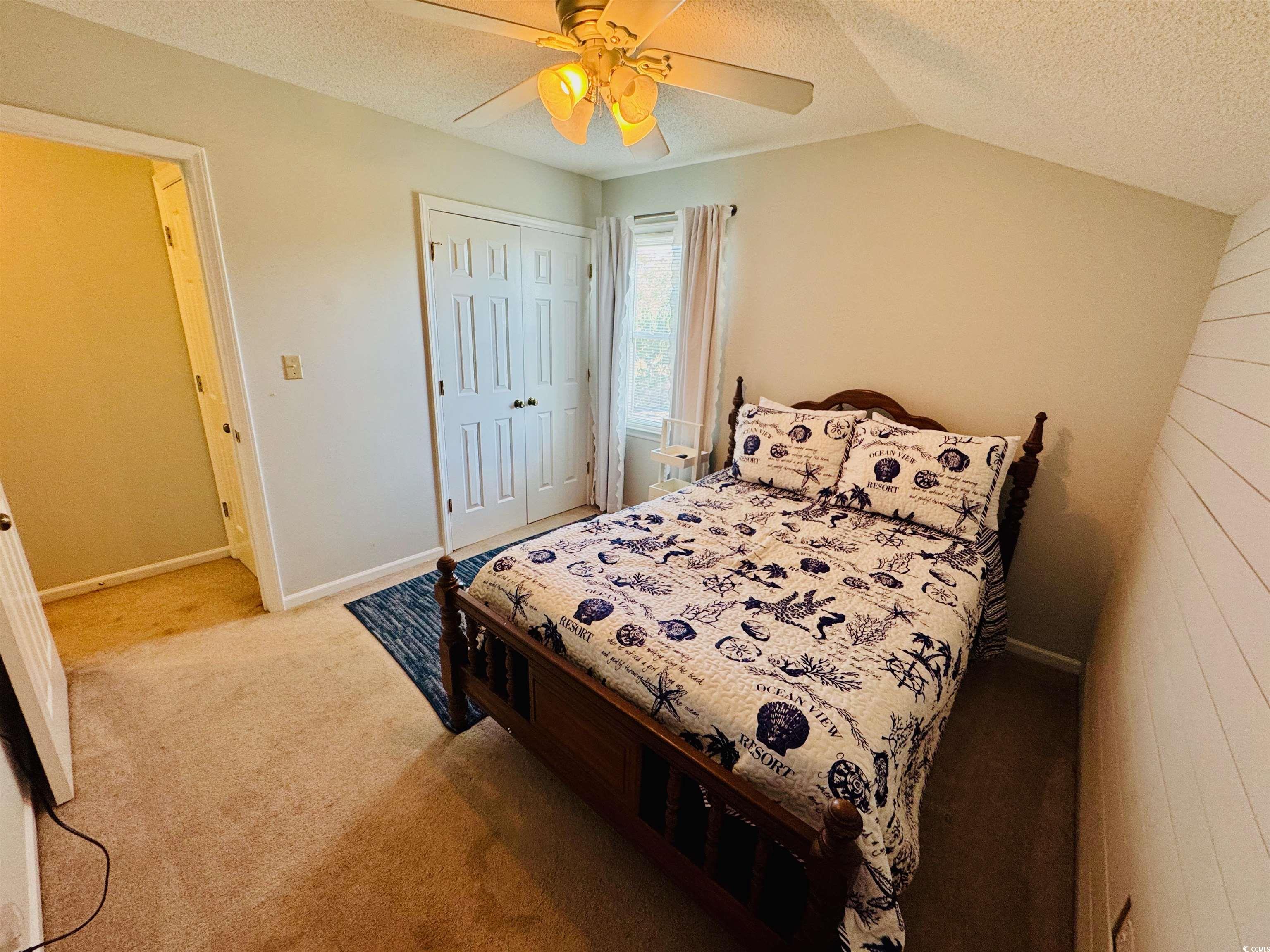 1960 Lake View Circle Surfside Beach, SC 29575 - Photo 28 of 40 Bedroom featuring a textured ceiling, ceiling fan, a closet, vaulted ceiling, and light colored carpet