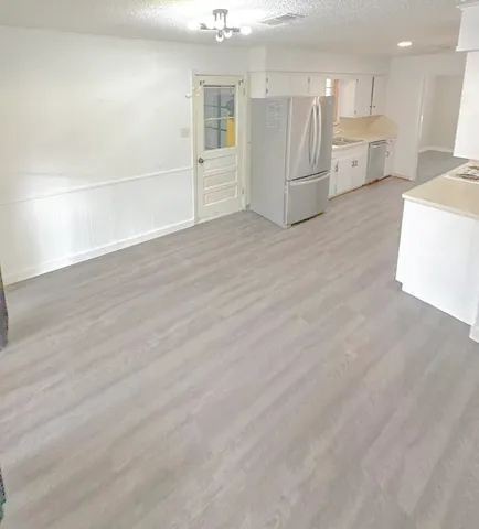 a view of a kitchen with a sink and a refrigerator