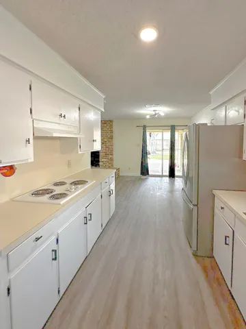 a large kitchen with a lot of counter space and wooden floor