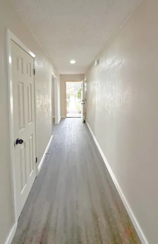 a view of a hallway with wooden floor