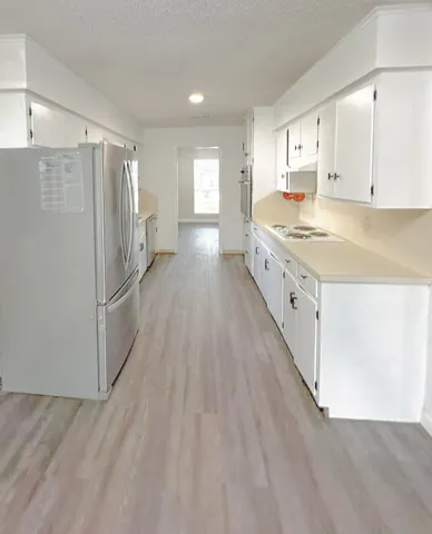a large kitchen with a lot of counter space and wooden floor
