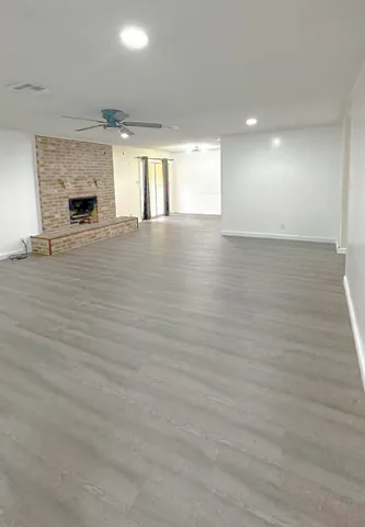 an empty room with wooden floor and fireplace