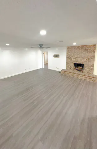 an empty room with wooden floor and fireplace