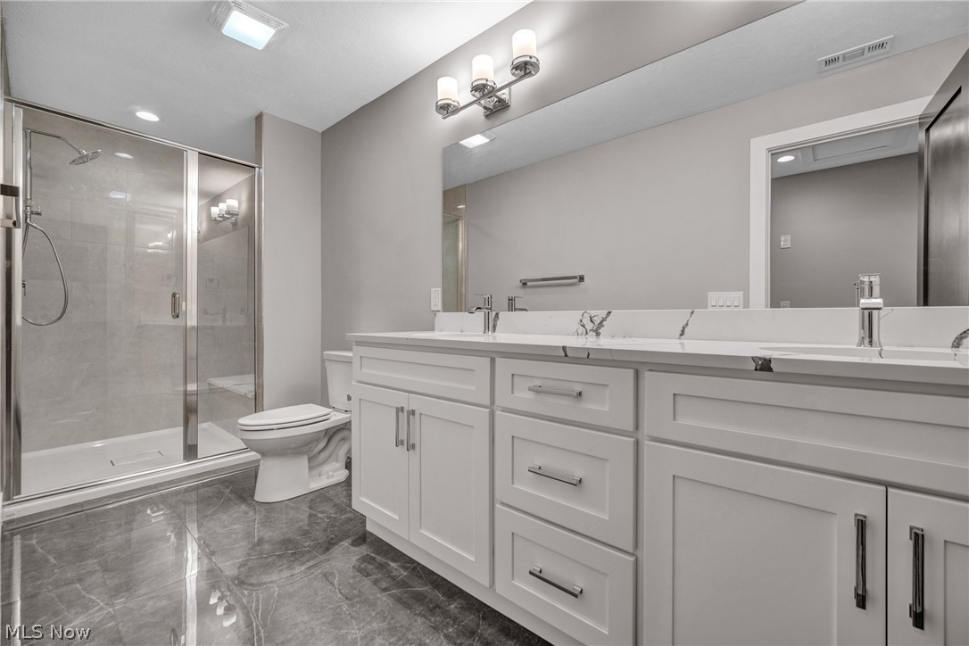 4009 Brainard Road Beachwood, OH 44122 - Photo 40 of 50 Bathroom featuring a shower with door, double vanity, toilet, and tile patterned floors