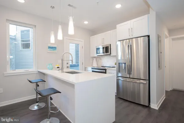 a kitchen with kitchen island a appliances a sink and a refrigerator