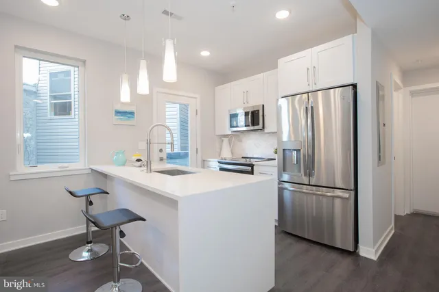 a kitchen with kitchen island a appliances a sink and a refrigerator