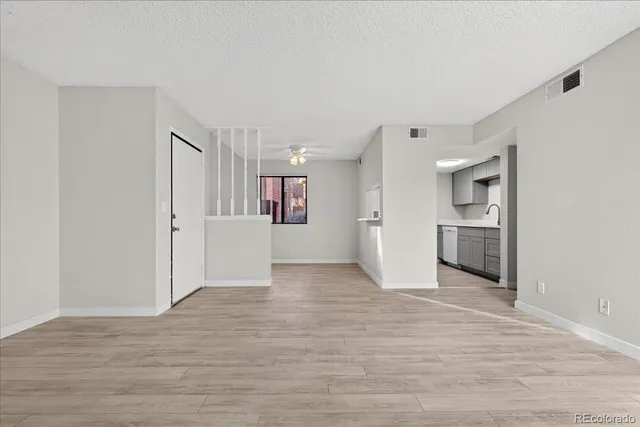 a view of a kitchen with an empty space and wooden floor