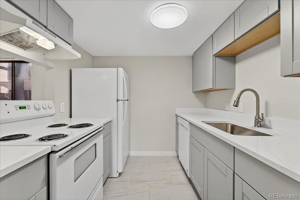 4681 South Decatur Street, Unit 124 Englewood, CO 80110 - Photo 18 of 33 a kitchen with stainless steel appliances granite countertop a sink stove and refrigerator