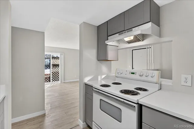 a kitchen with a stove cabinets and wooden floor