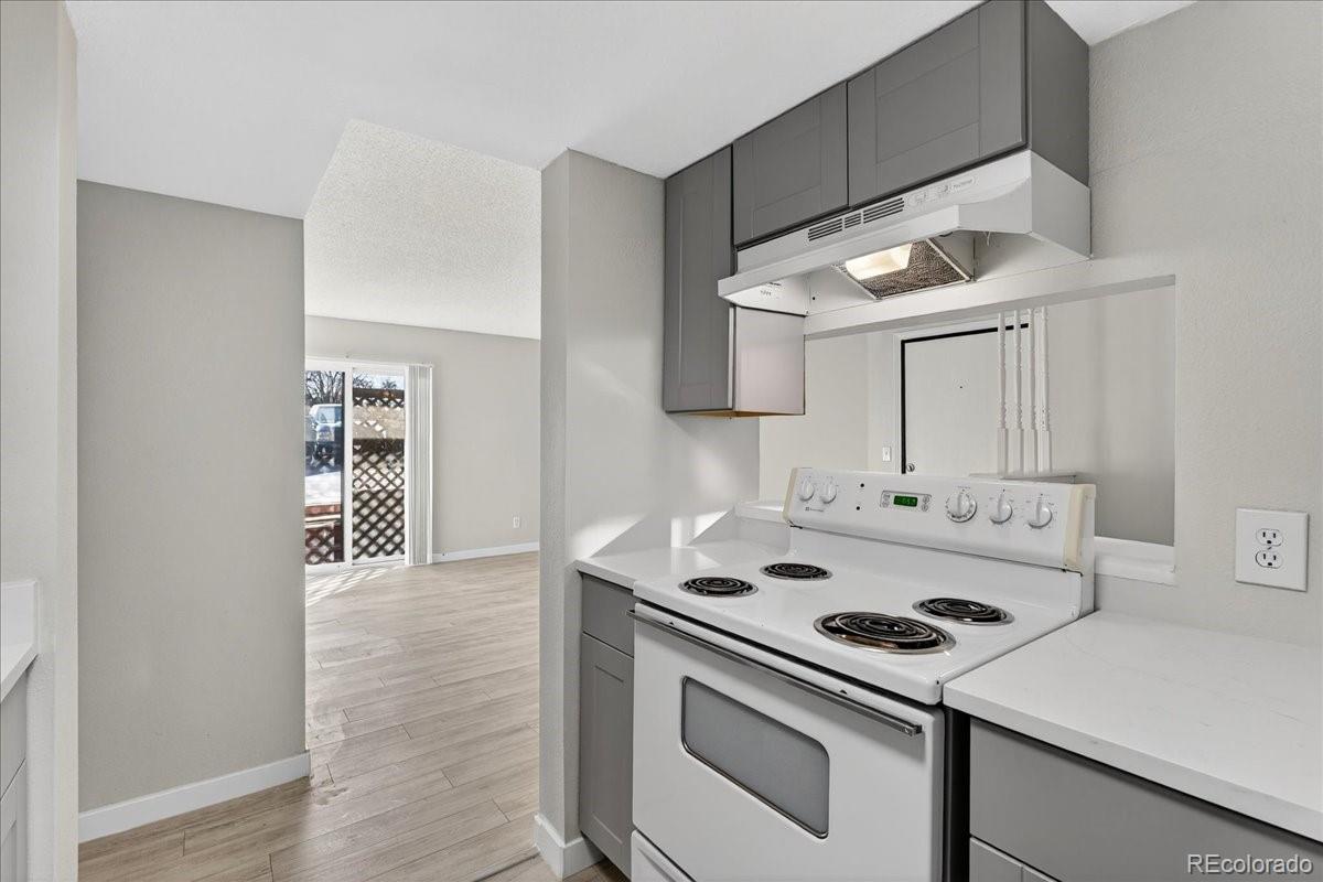 4681 South Decatur Street, Unit 124 Englewood, CO 80110 - Photo 20 of 33 a kitchen with a stove cabinets and wooden floor