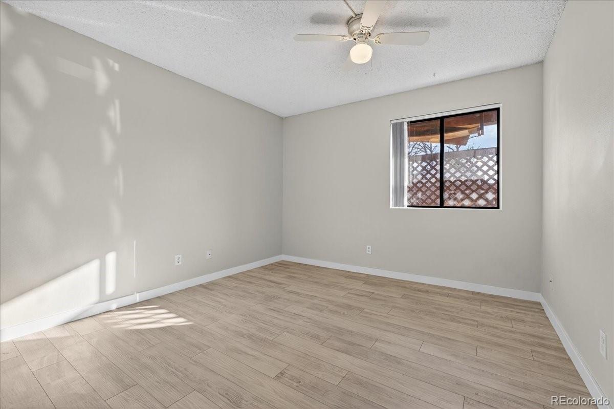 4681 South Decatur Street, Unit 124 Englewood, CO 80110 - Photo 23 of 33 a view of an empty room with wooden floor and a ceiling fan