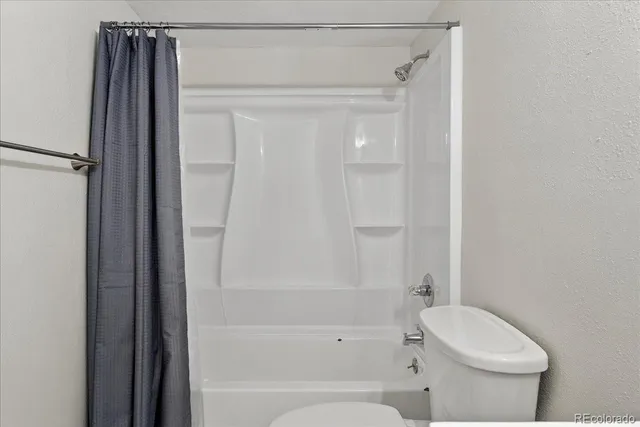 a bathroom with a toilet and a shower