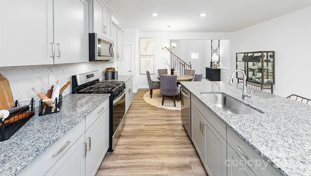 a large kitchen with stainless steel appliances granite countertop a lot of counter space