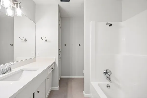 a bathroom with a tub sink double vanity granite and shower