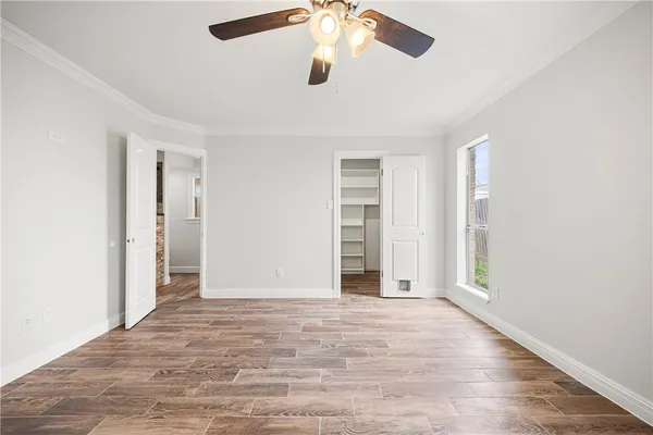 an empty room with closet and windows
