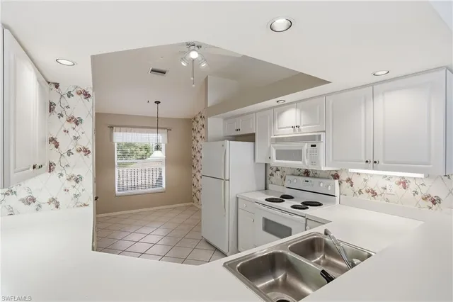 a kitchen with granite countertop a stove a sink and a refrigerator