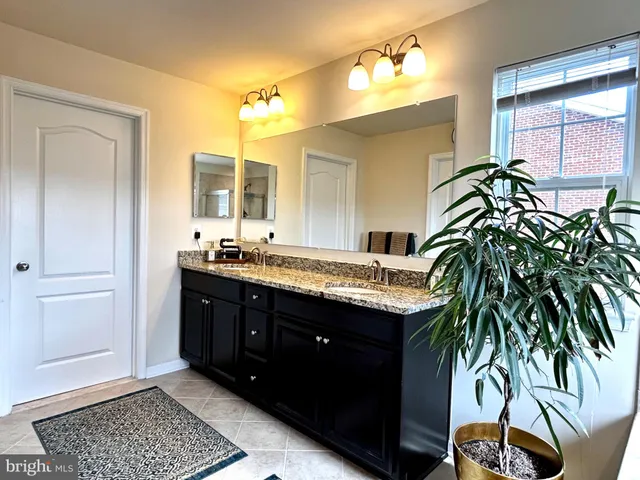 a spacious bathroom with a granite countertop sink a mirror and a shower