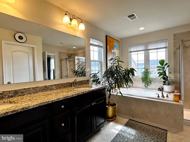 a bathroom with a granite countertop sink and a large mirror