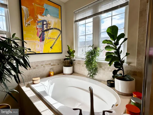 a bathroom with a tub sink and mirror