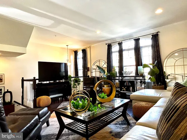 a living room with furniture a flat screen tv and a floor to ceiling window