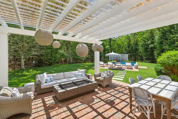 a view of a patio with couches table and chairs with wooden floor and garden view