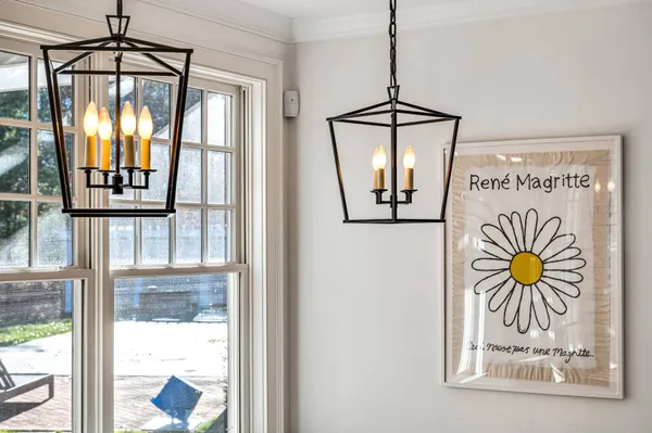 a dining room with wooden floor a chandelier a wooden table and chairs