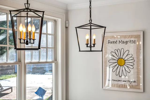 a dining room with wooden floor a chandelier a wooden table and chairs