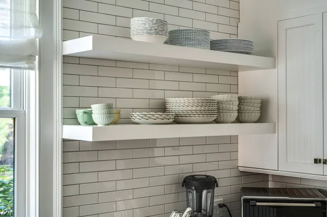 a kitchen with stainless steel appliances granite countertop a stove top oven a sink dishwasher a dining table and chairs with wooden floor