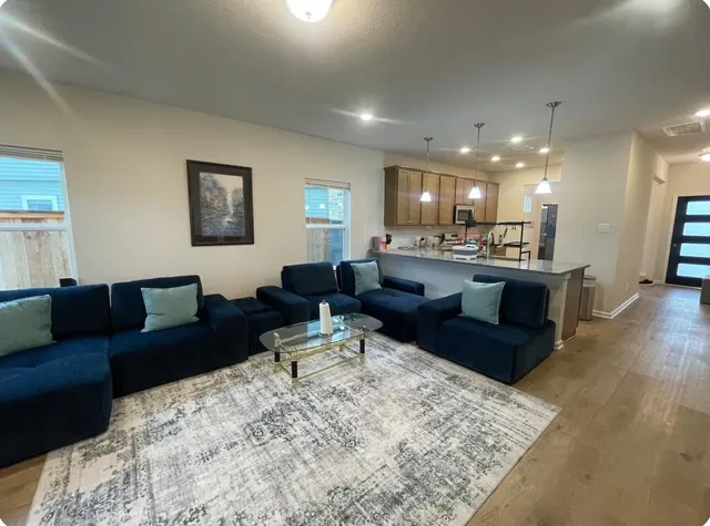 a living room with furniture and a wooden floor