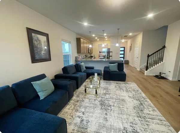 a living room with furniture and a wooden floor