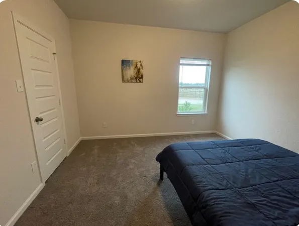 a bed sitting in a bedroom next to a window