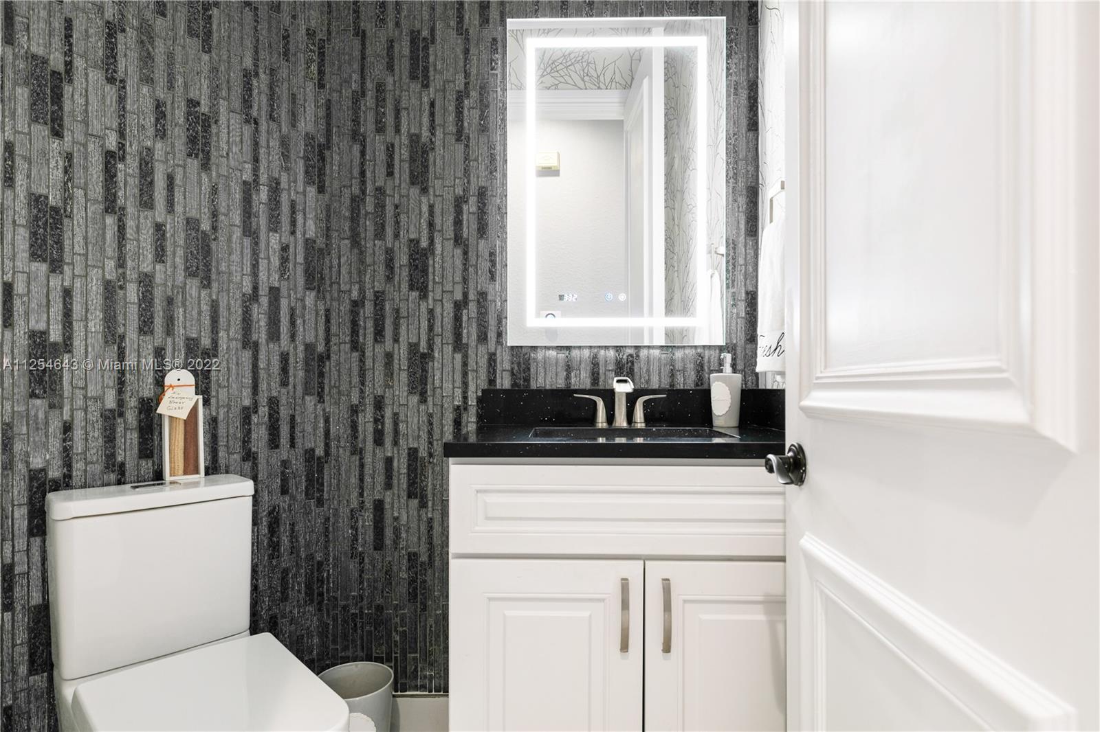 6563 Northwest 127th Terrace Parkland, FL 33076 - Photo 24 of 97 a bathroom with a sink a toilet and a mirror