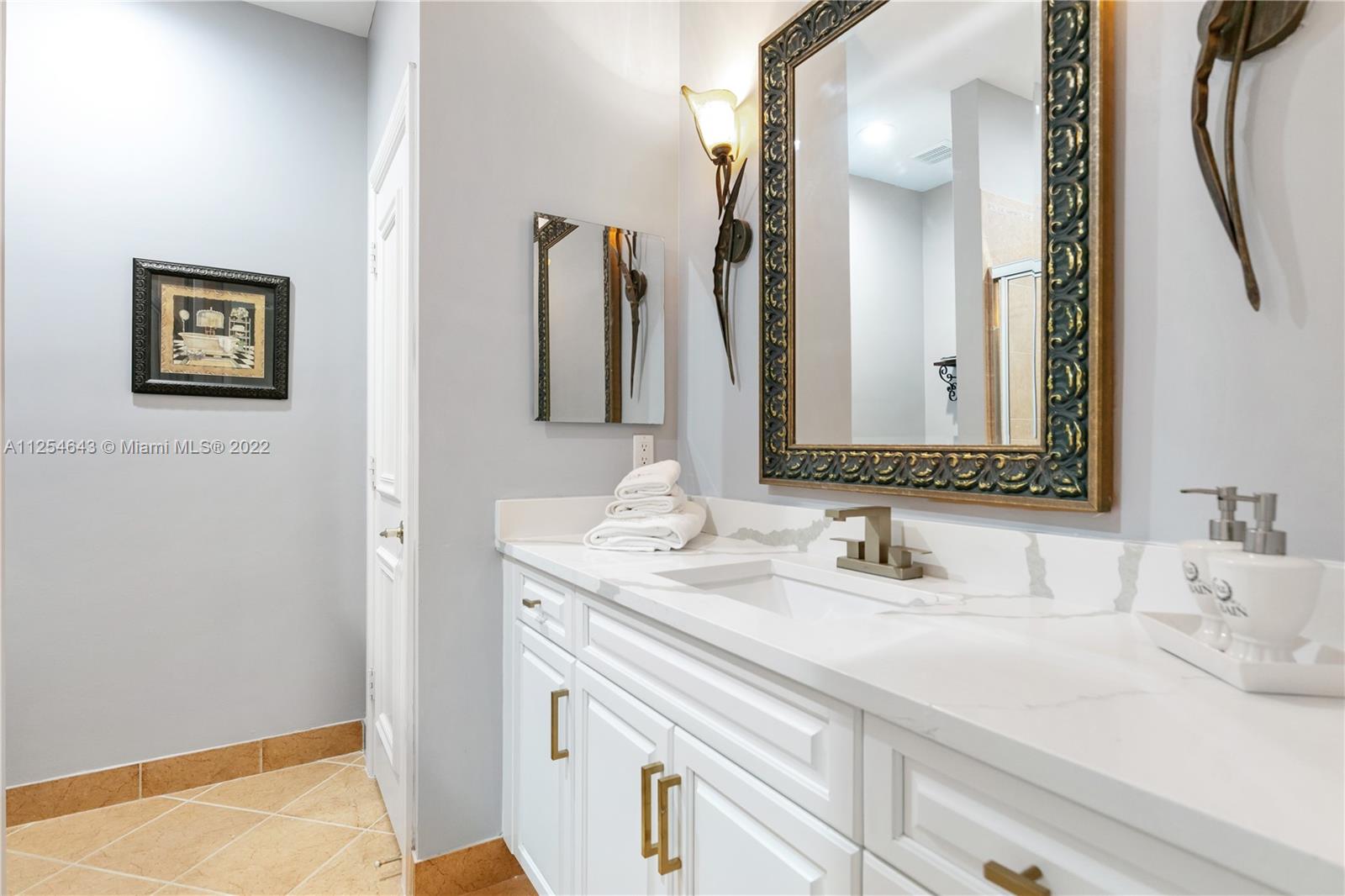 6563 Northwest 127th Terrace Parkland, FL 33076 - Photo 32 of 97 a bathroom with a sink and a mirror