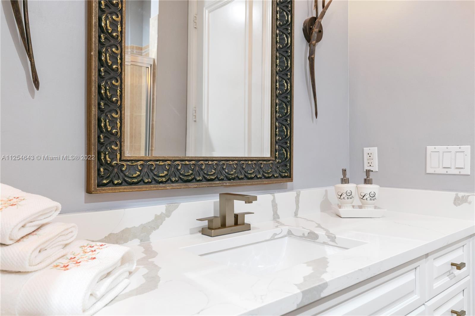 6563 Northwest 127th Terrace Parkland, FL 33076 - Photo 35 of 97 a bathroom with a sink and a mirror