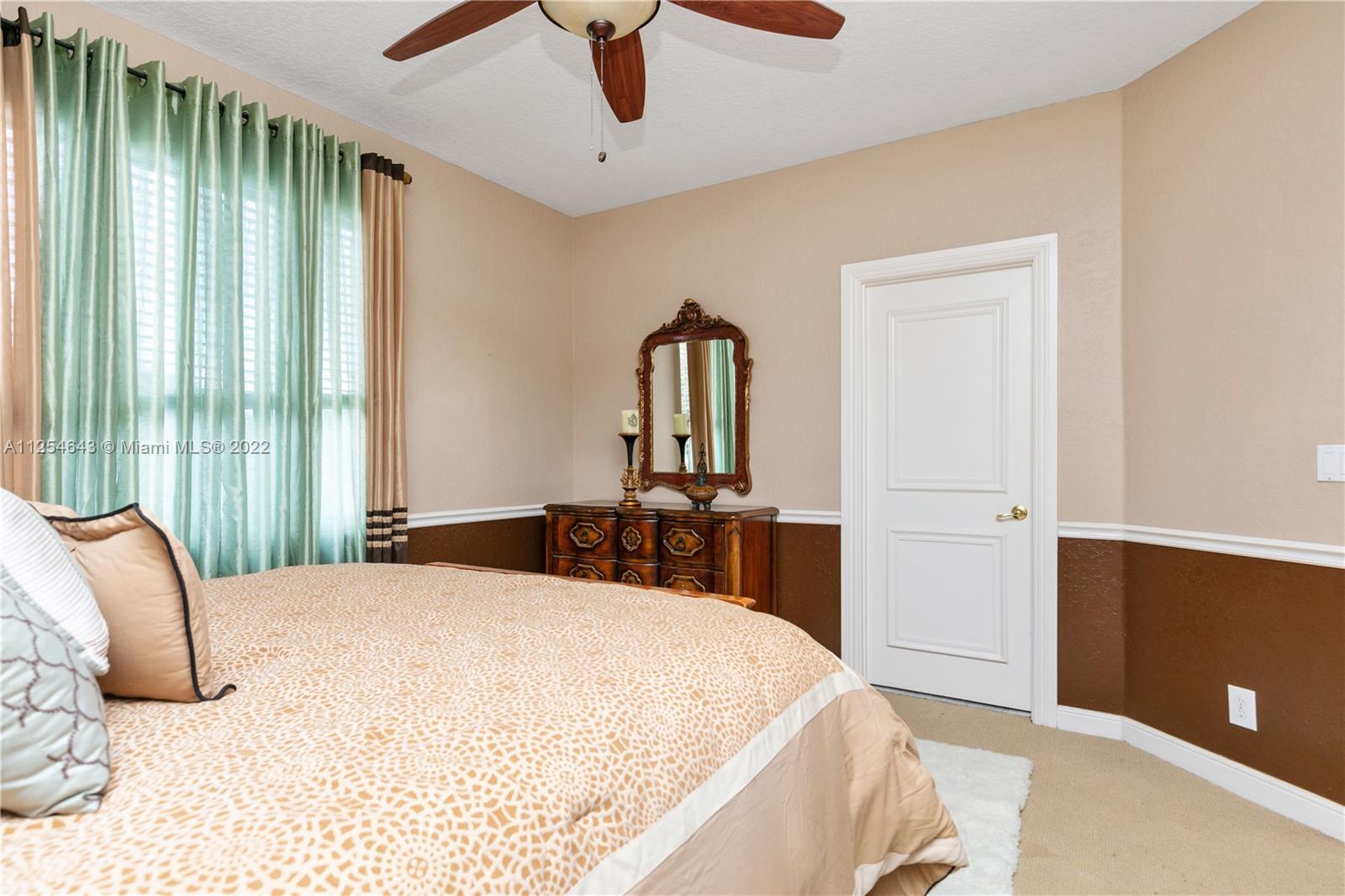 6563 Northwest 127th Terrace Parkland, FL 33076 - Photo 37 of 97 a bedroom with a bed and a chandelier