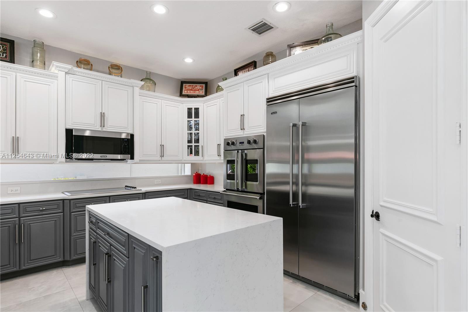 6563 Northwest 127th Terrace Parkland, FL 33076 - Photo 46 of 97 a kitchen with stainless steel appliances a refrigerator sink and microwave