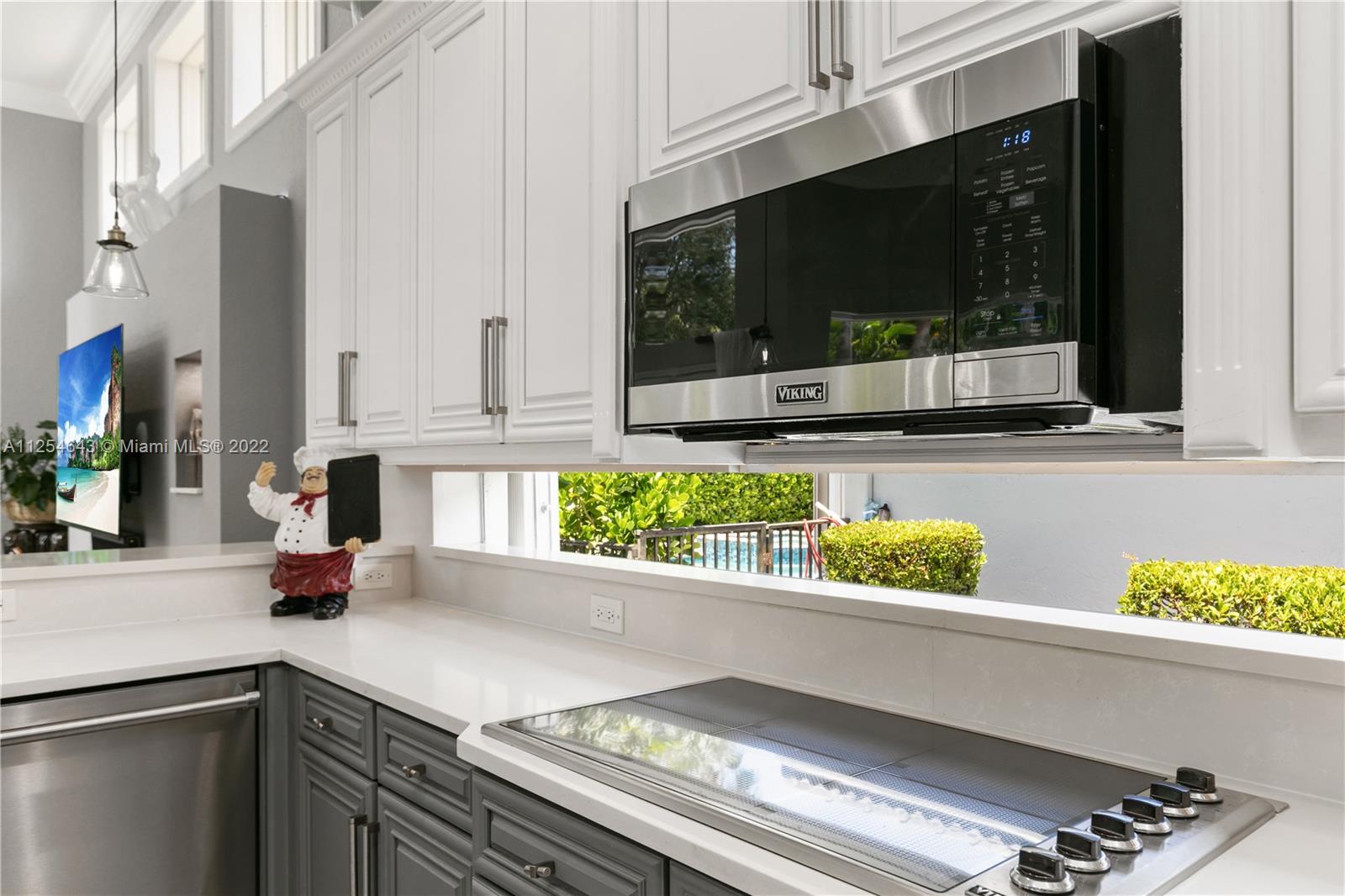 6563 Northwest 127th Terrace Parkland, FL 33076 - Photo 49 of 97 a kitchen with a stove a microwave and cabinets