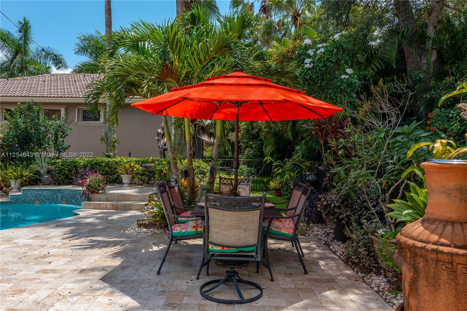 6563 Northwest 127th Terrace Parkland, FL 33076 - Photo 67 of 97 a view of a backyard with table and chairs under an umbrella