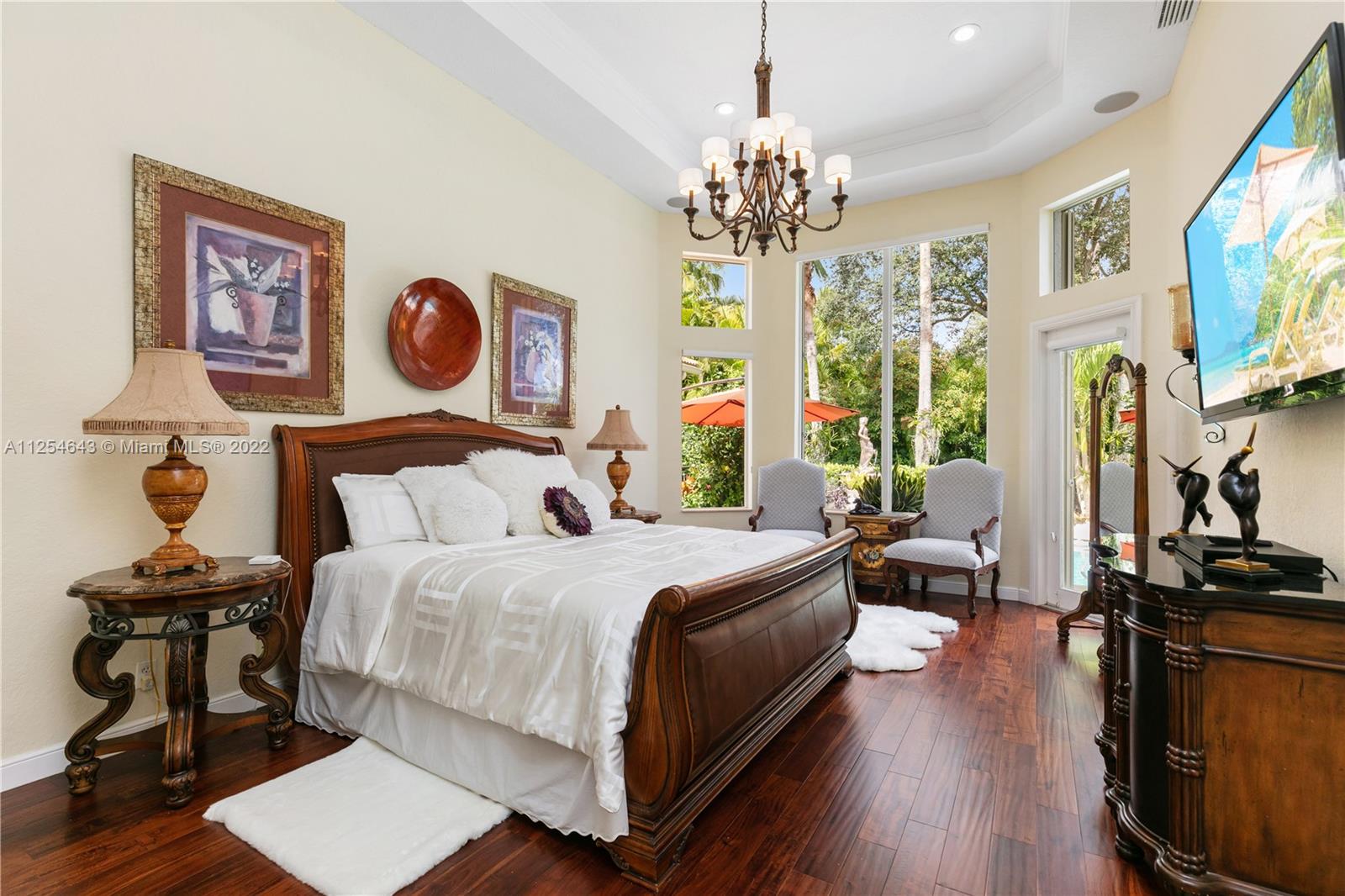 6563 Northwest 127th Terrace Parkland, FL 33076 - Photo 8 of 97 a bedroom with a bed and a chandelier